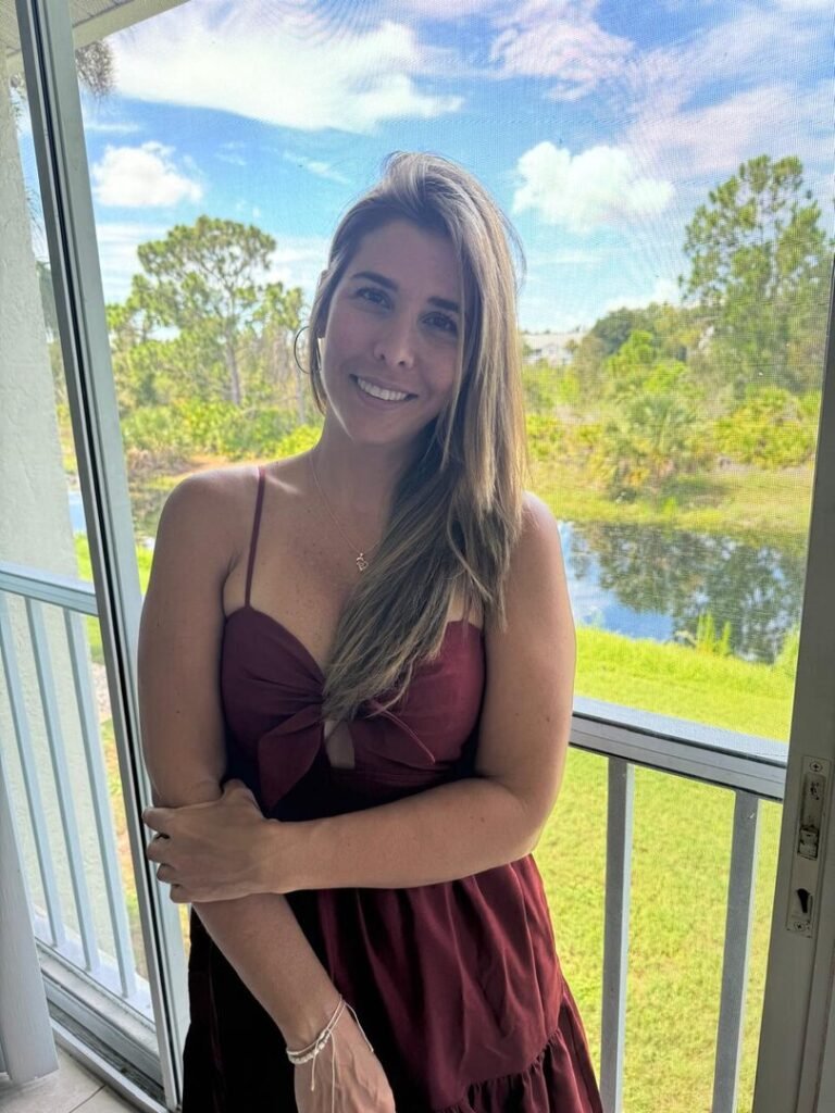 Mujer sonriendo con luz natural en un balcón, en paz consigo misma después de los 40